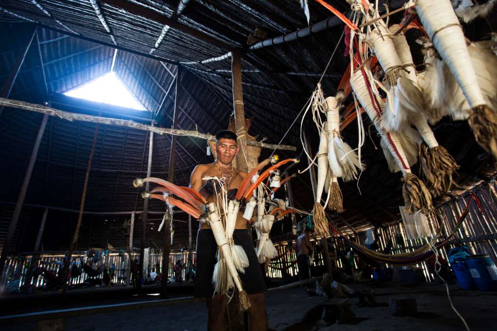 Joven indígena del resguardo Yaigojé Apaporis alistando traje tradicional para ritual amazónico.