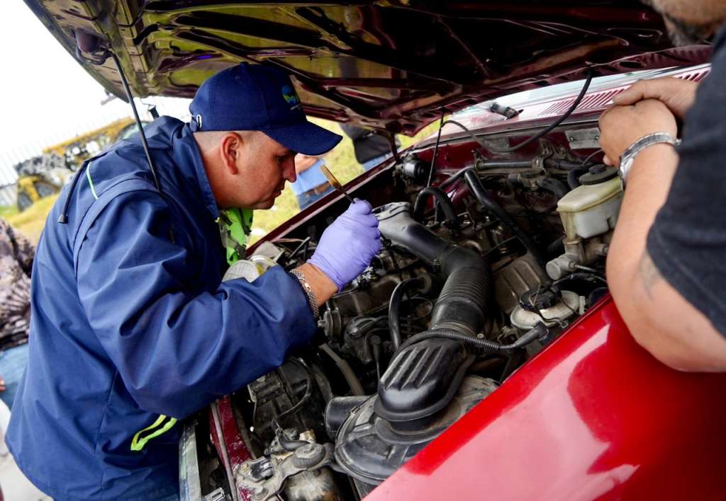 Funcionarios de la CAR inspeccionan vehículos para comprobar si cumplen las normas ambientales.