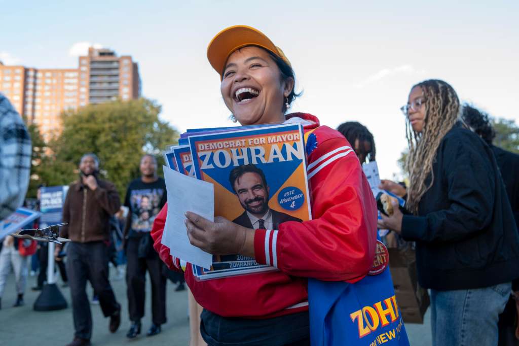 AME2187. NUEVA YORK (ESTADOS UNIDOS), 26/10/2025.- Una persona muestra una publicidad del candidato a la alcaldía de Nueva York, el asambleísta Zohran Mamdani, durante el mitin 'New York no está a la venta' este domingo, en el estadio de tenis de Forest Hills, Nueva York (Estados Unidos). Foto EFE/ Ángel Colmenares
