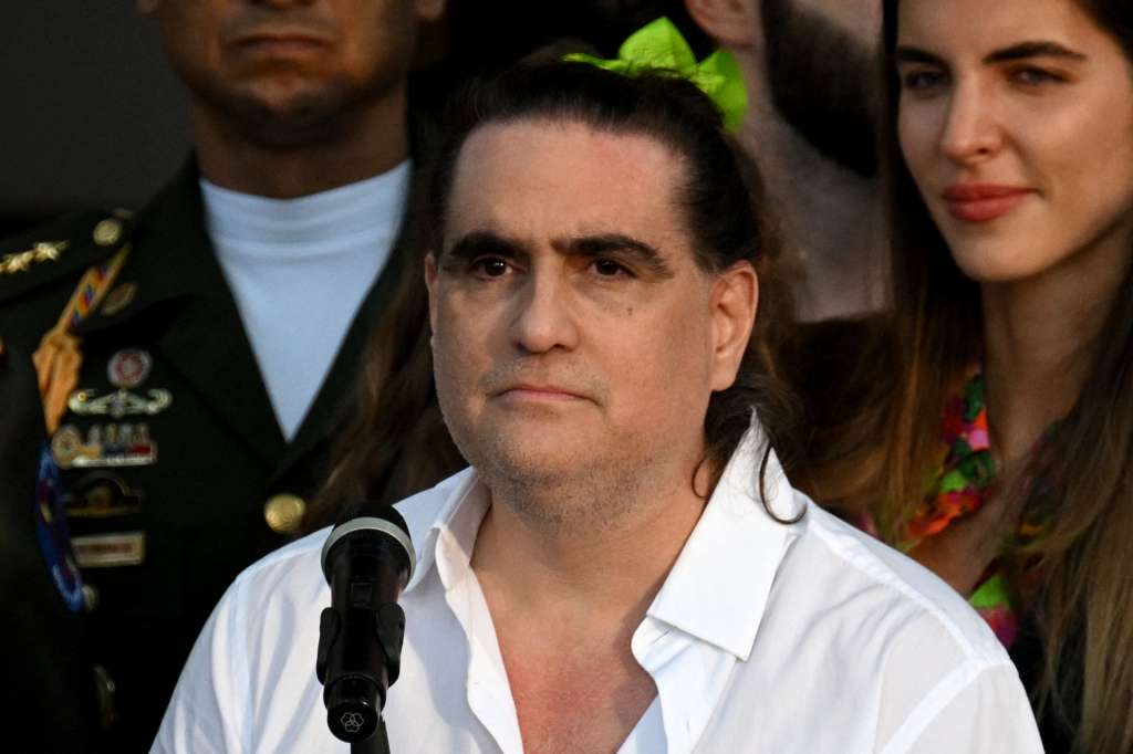 (FILES) Colombian businessman Alex Saab speaks next to his wife, Camilla Fabri (R), at the Miraflores Presidential Palace in Caracas on December 20, 2023.