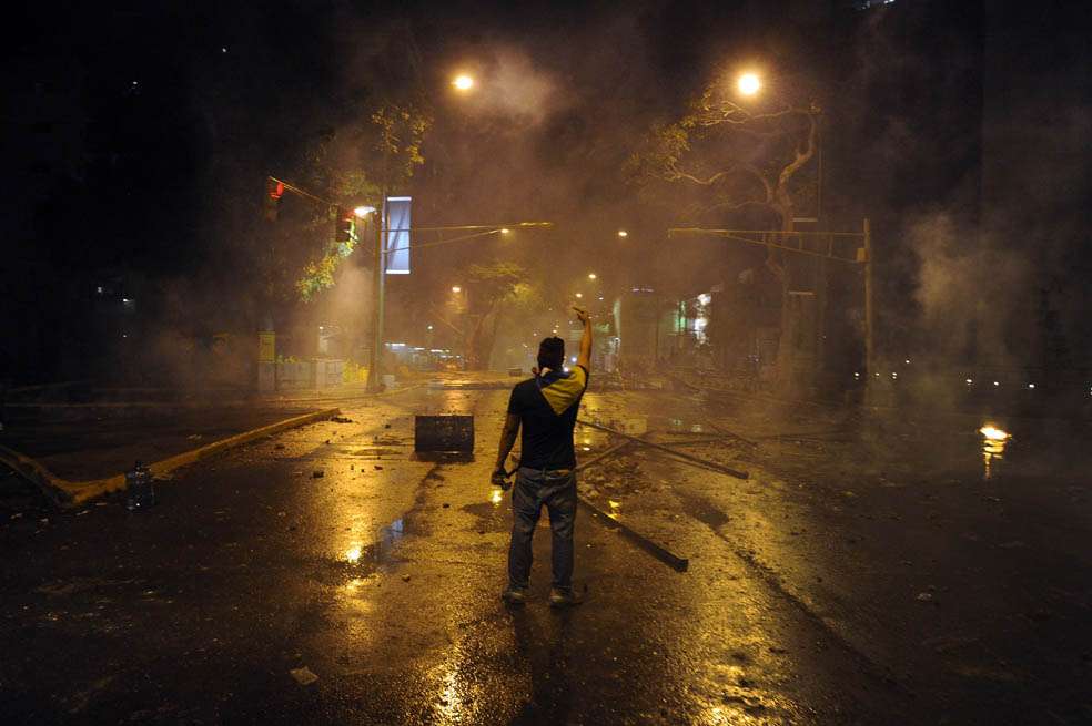 Un manifestante confronta a las autoridades durante protestas contra el gobierno en Caracas. / AFP
