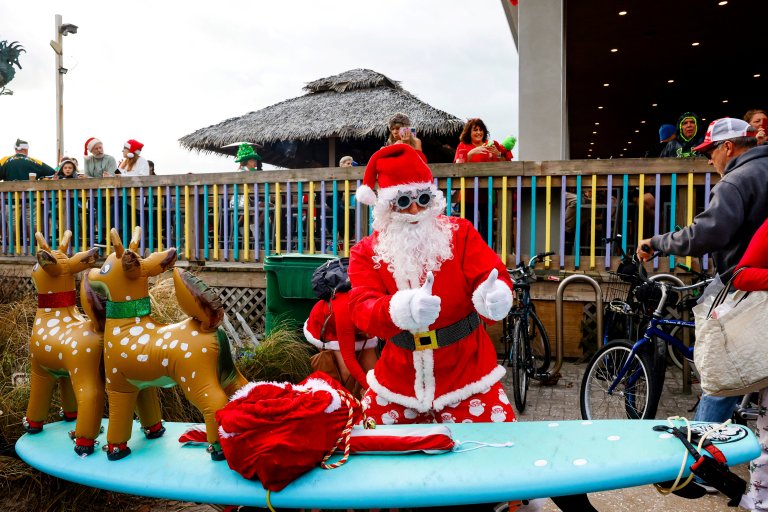 Surfistas disfrazados de Papá Noel se toman playa de Florida por una buena causa