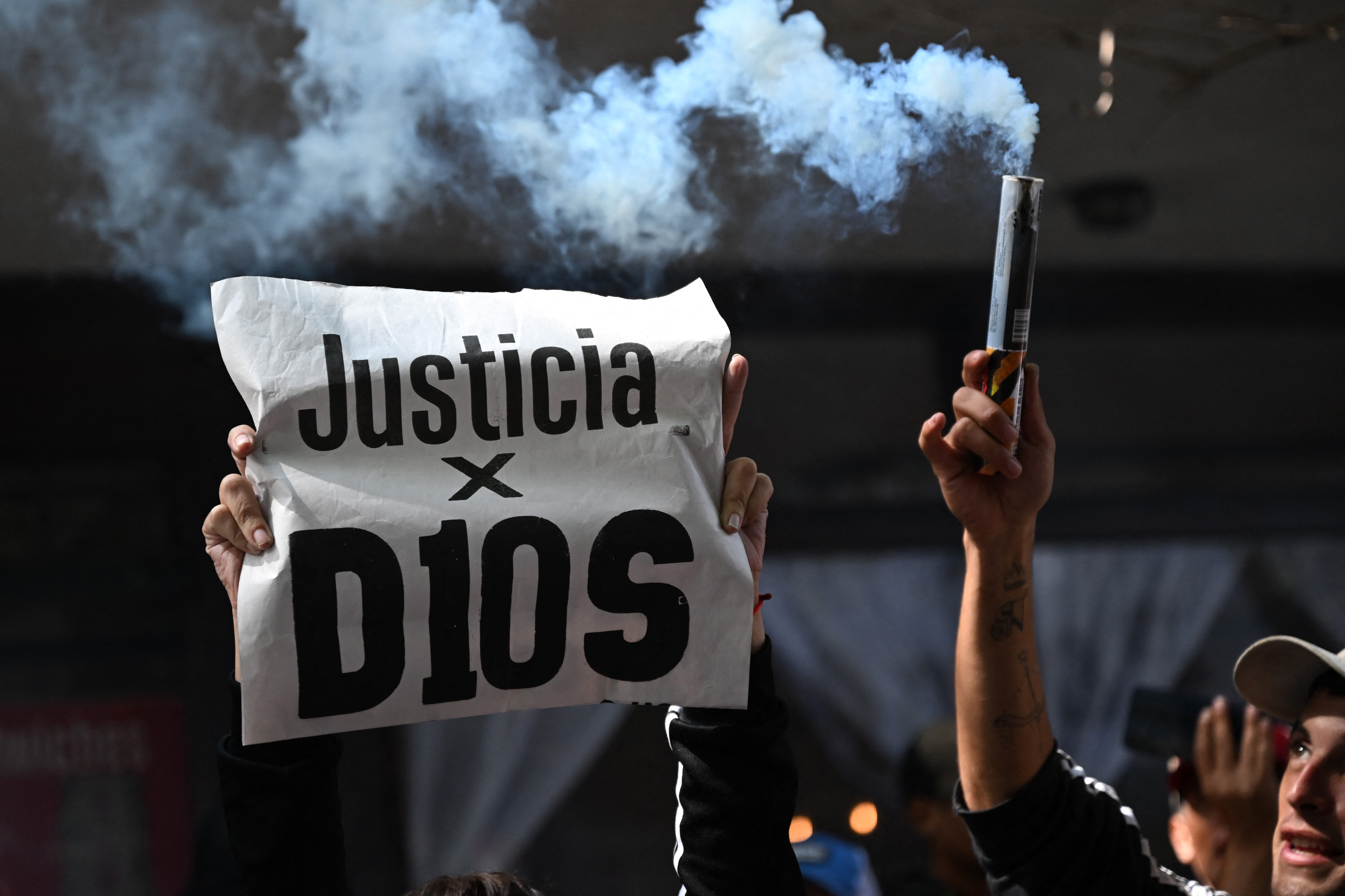 Un aficionado sostiene una pancarta que dice en español 'Justicia para los D10' mientras espera fuera del tribunal de San Isidro durante el juicio por la muerte de la leyenda del fútbol argentino Diego Maradona en San Isidro, provincia de Buenos Aires, Argentina, el 11 de marzo de 2025. Cuatro años después de la muerte de Diego Maradona, el juicio a siete profesionales de la salud comienza este martes en Argentina para determinar sus responsabilidades en la muerte de la leyenda del fútbol.