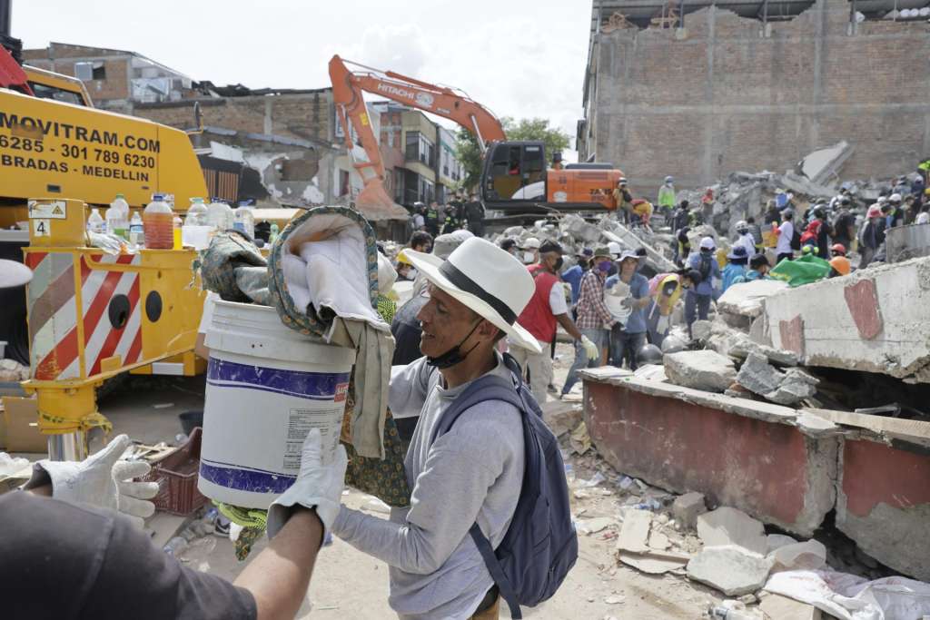 AME8355. PEREIRA (COLOMBIA), 12/08/2026.- Voluntarios realizan una cadena humana para sacar escombros de edificaciones destruidas por el terremoto de magnitud 7,4 del pasado lunes, este miércoles en Pereira (Colombia). EFE/ Carlos Ortega