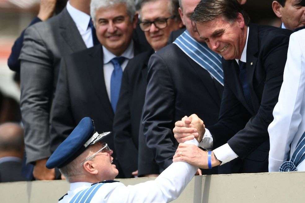 El presidente brasileño Jair Bolsonaro (derecha) saluda al teniente de brigada Antonio Carlos Moretti durante su ceremonia de posesión.