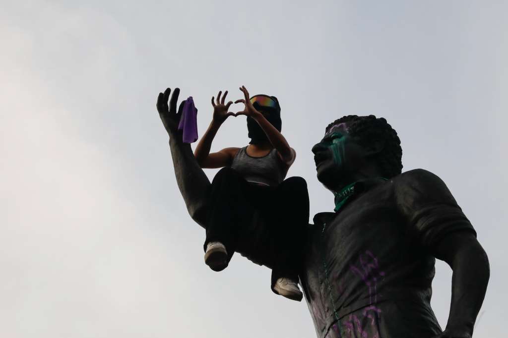 AME7862. BOGOTÁ (COLOMBIA), 08/03/2025.- Una mujer se sienta en la estatua de Luis Carlos Galán durante una manifestación en el marco del Día Internacional de la Mujer este sábado, en Bogotá (Colombia). EFE/ Vannessa Jiménez