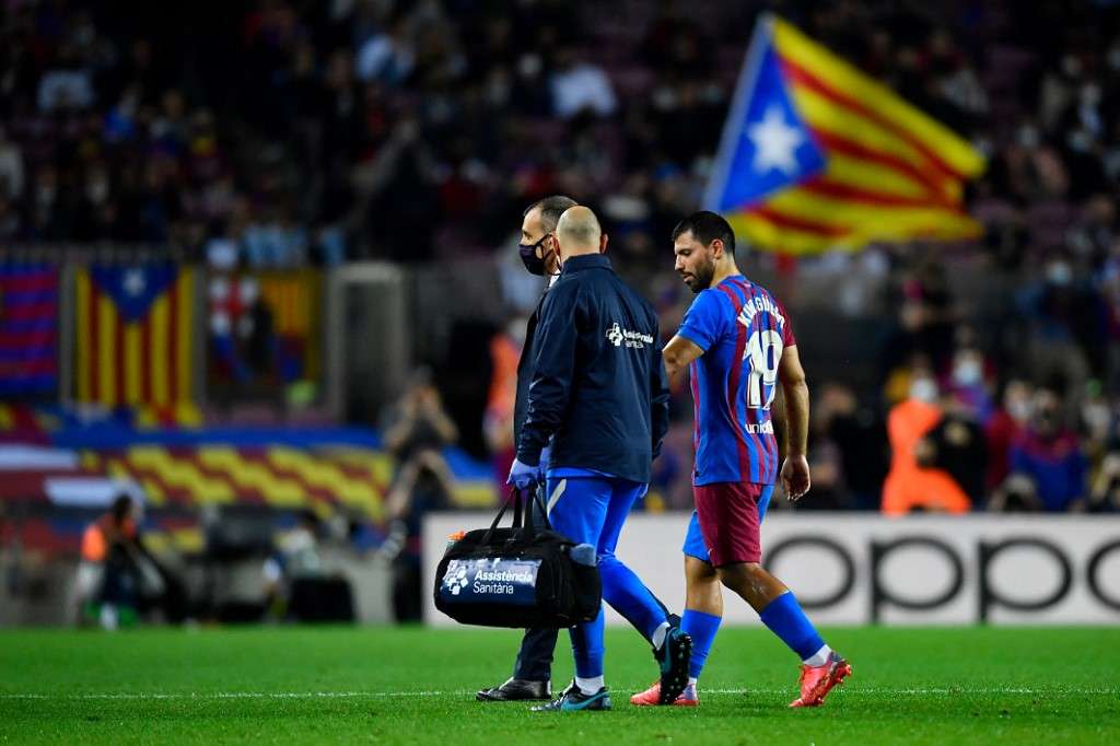 Sergio 'Kun' Agüero (der.) se retira del césped del Camp Nou tras sufrir el malestar en su pecho.