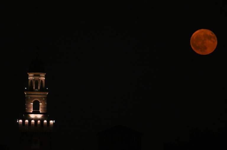 La luna llena, conocida como la “Luna de Fresa”, se eleva sobre la torre del Castillo Sforza en Milán, el 11 de junio de 2025.