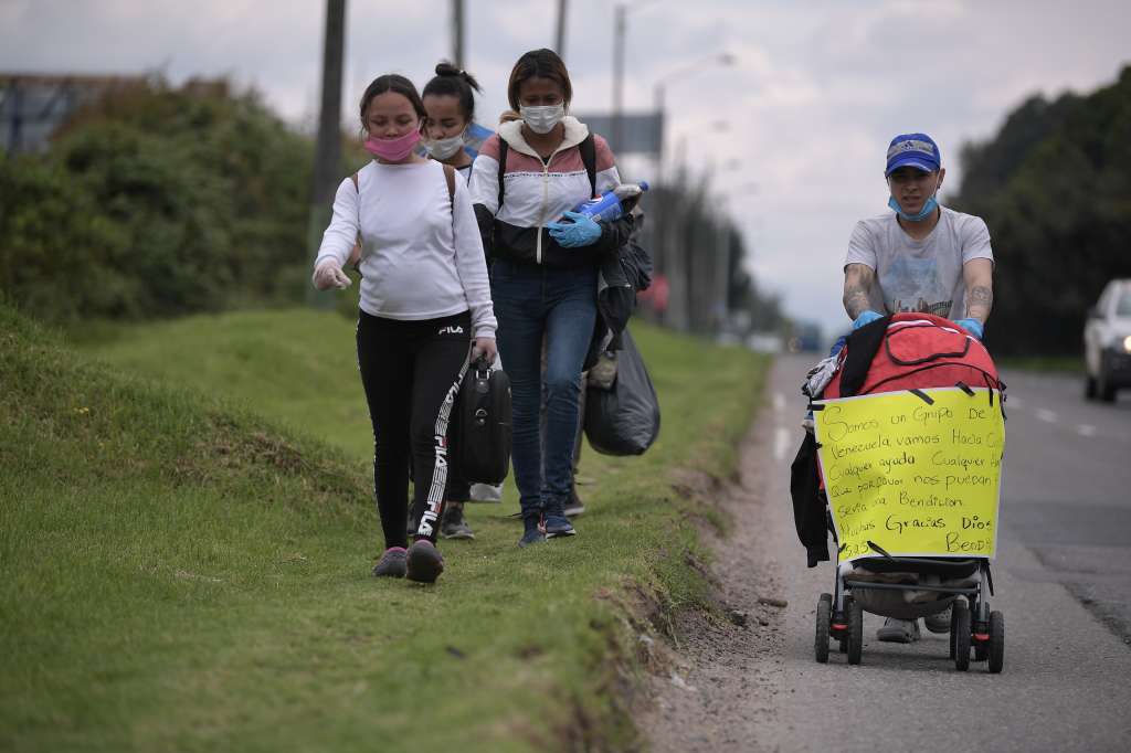 Migrantes venezolanos transitan por la autopista norte de Bogotá de regreso a Venezuela, en medio de la cuarentena obligatoria por cuenta del Covid-19.