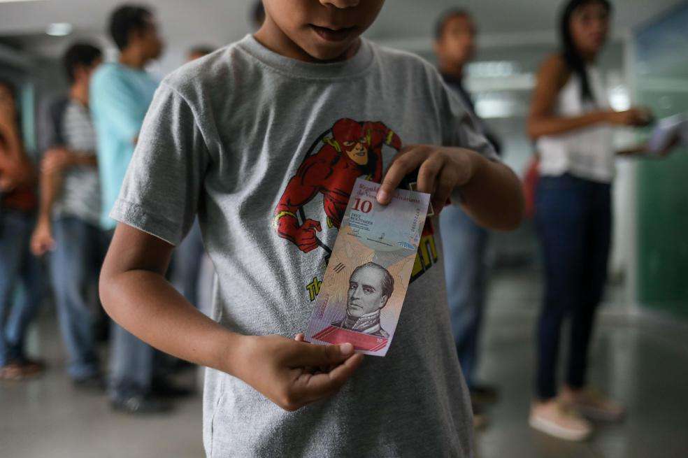 Imagen de referencia. Un niño muestra billete de Venezuela.