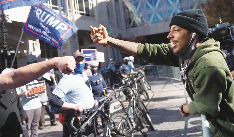 Philadelphia (United States), 05/11/2020.- A man leans over the barricades to gesture to the Trump rally in front of the Pennsylvania Convention Center in Philadelphia, Pennsylvania, USA, 05 November 2020. Counting of mail-in ballots in Pennsylvania began on 03 November and is expected to stretch to 06 November. (Estados Unidos, Filadelfia) EFE/EPA/TRACIE VAN AUKEN
