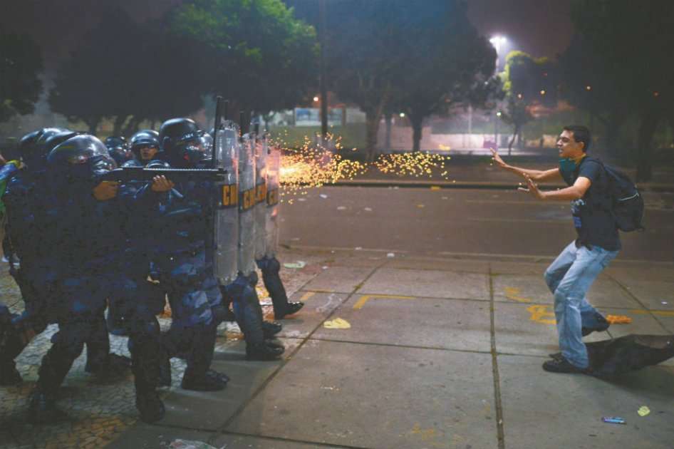 La policía dispara balas de goma contra un manifestante en Río de Janeiro, Brasil. / AFP