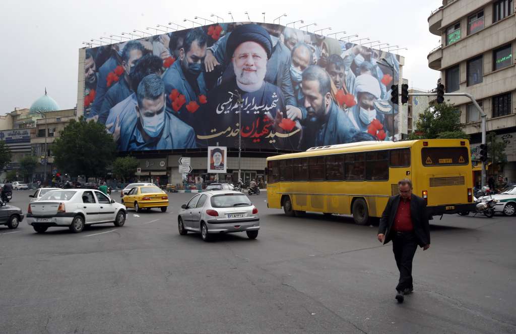 Tehran (Iran(islamic Republic Of)), 21/05/2024.- Iranians drive past a poster of late Iranian president Ebrahim Raisi at Enghelab Square in Tehran, Iran, 21 May 2024. Iranian president Raisi and seven others, among them foreign minister Amir-Abdollahian, were killed in a helicopter crash on 19 May 2024, after an official visit in Iran's northwest near the border with Azerbaijan, the Iranian government confirmed. Iran's Supreme Leader Ayatollah Ali Khamenei on 20 May announced a five-day public mourning following Raisi's death. (Azerbaiyán, Teherán) EFE/EPA/ABEDIN TAHERKENAREH