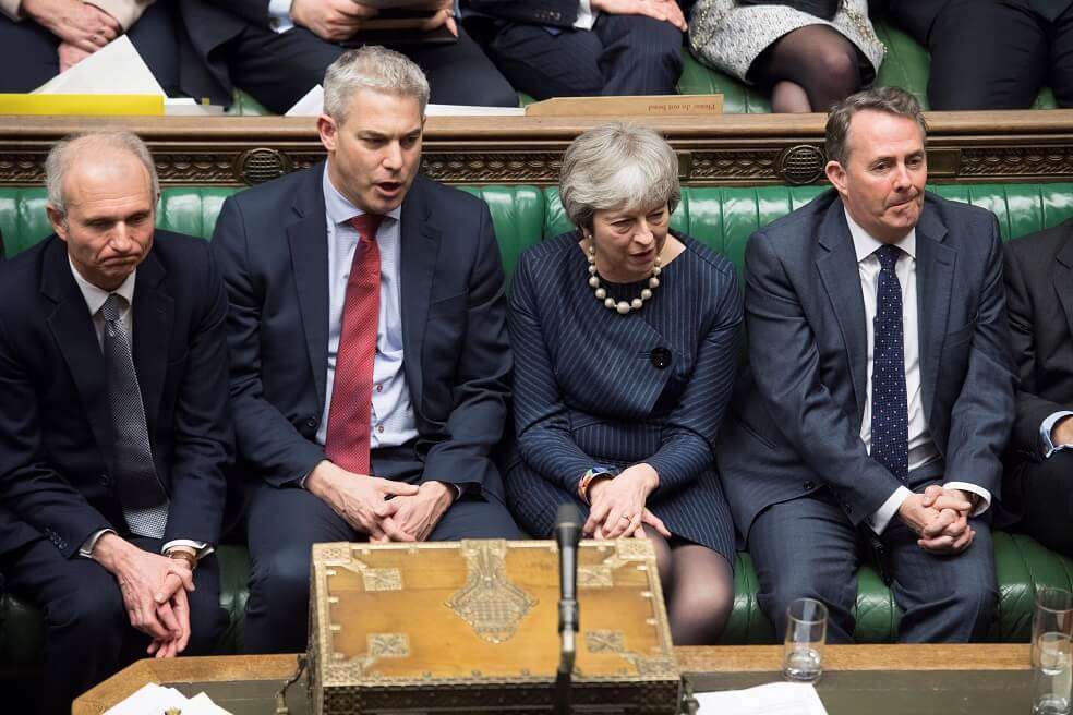 La primera ministra británica Theresa May junto a miembros de su bancada en la Cámara de los Comunes. / EFE