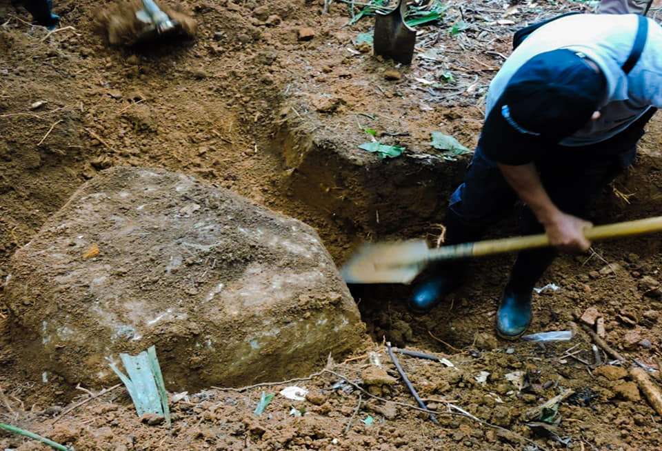 Hombre de espaldas está excavando para hallar el cuerpo de una persona desaparecida.