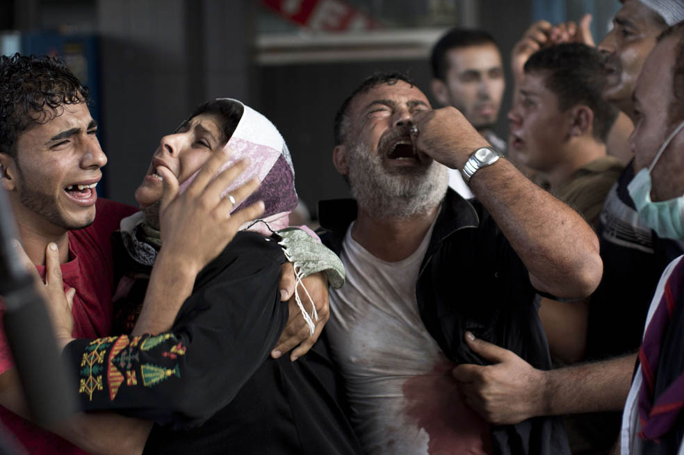 Palestinos lloran a sus familiares en el hospital Al Shifa, en la Franja de Gaza. Más de 1.000 gazatíes han muerto bajo bombardeos de Israel. / AFP
