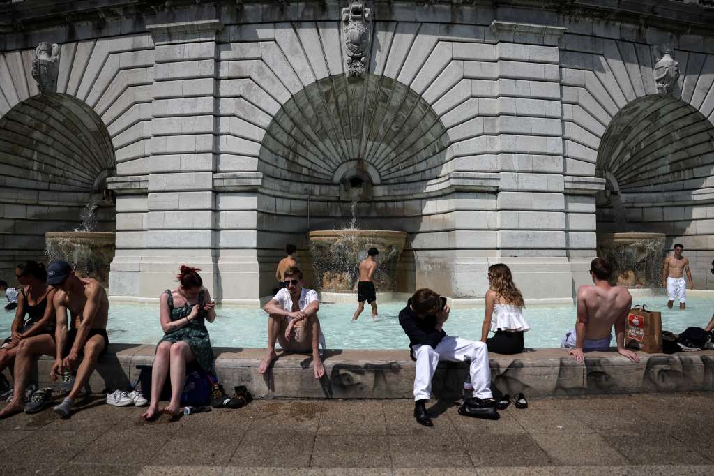 (FILES) People cool off in a fountain on square Louise Michel in Montmartre in Paris, on July 30, 2024.