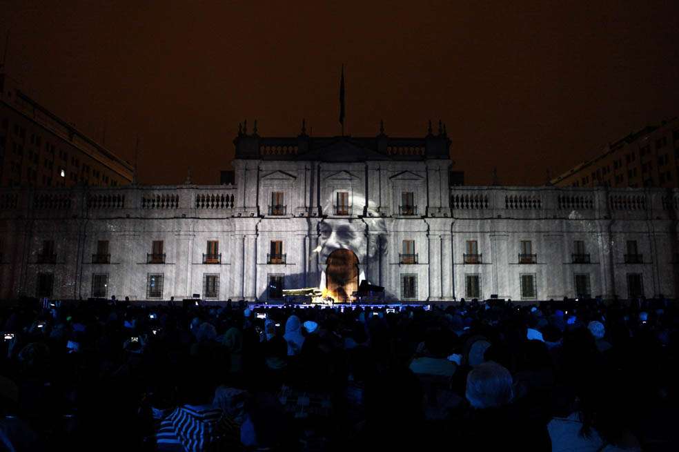 Cristobal Ugarte, nieto de Nicanor Parra, dio un concierto de piano durante la celebración del centenario en el Palacio de la Moneda. De fondo, el poeta. / EFE