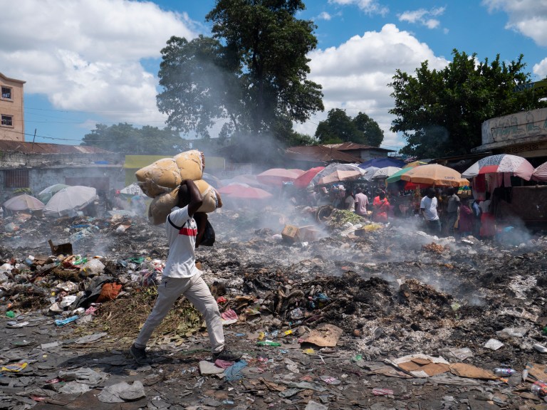 -FOTODELDÍA- AME3017. PUERTO PRÍNCIPE (HAITÍ), 08/10/2022.- Un hombre camina por una calle cubierta de basura que no ha sido recogida, hoy en Puerto Príncipe (Haití) El pedido del Gobierno haitiano a sus socios internacionales para el despliegue "inmediato de una "fuerza armada especializada" dirigida a enfrentar la grave situación del país, es considerado "desestabilizador" por algunos sectores y, presuntamente, resultado de una acción "planificada". Haití está sumido en una grave crisis en todos los órdenes que prácticamente ha paralizado el país, y que se agravó a partir del asesinato, en julio de 2021, del presidente Jovenel Moise. EFE/ Carvens Adelson
