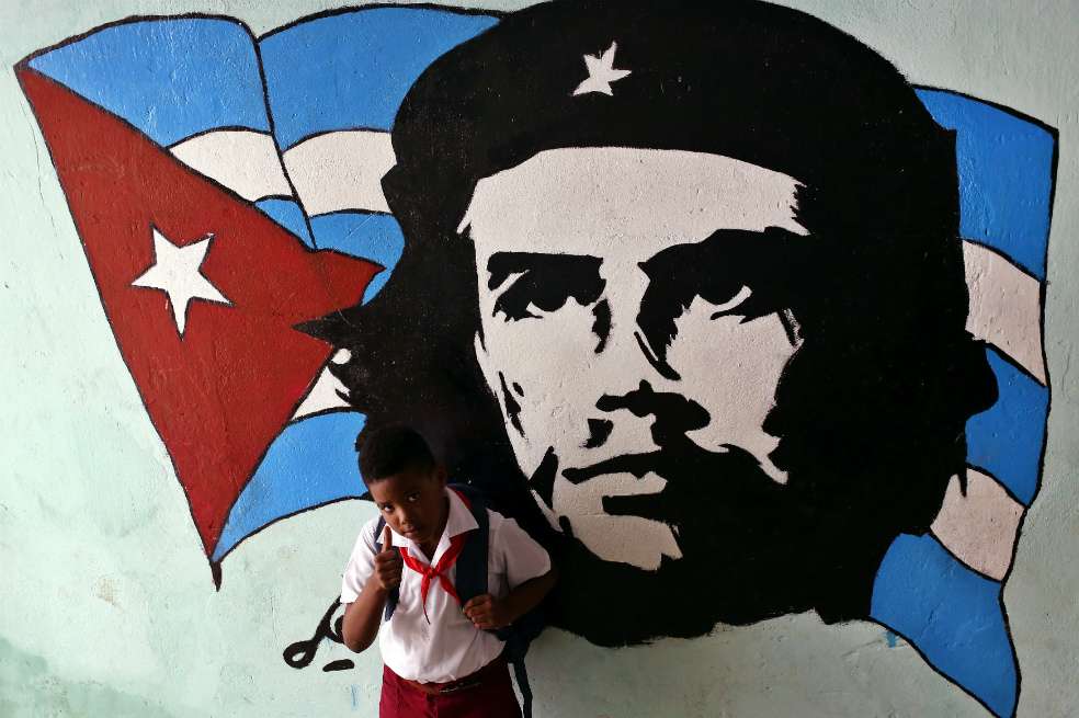 Un niño posa junto a un graffiti del Che Guevara, en La Habana (Cuba). La célebre imagen del Che Guevara que inmortalizó Korda se replica en cada esquina de Cuba, en sedes de instituciones oficiales y escuelas en honor a quien fue "guerrillero heroico" de la Revolución, convertido también, a los 50 años de su muerte, en un icono pop que se vende en tiendas de "souvenirs". / EFE