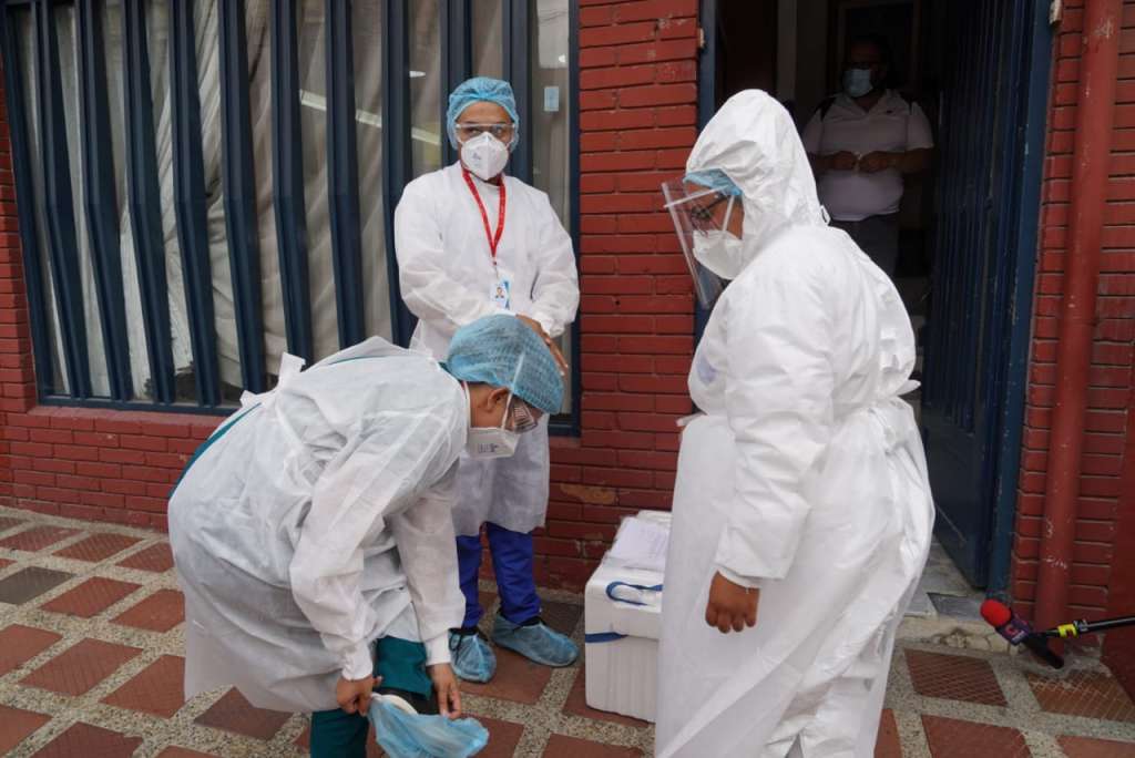 Tres mujeres con trajes de bioseguridad.