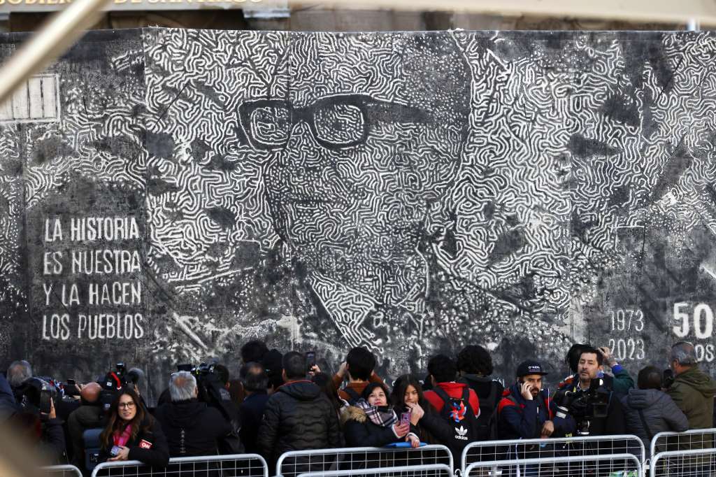 SANTIAGO (CHILE), 11/09/2023.- Personas se manifiestan durante un acto ciudadano en Conmemoración de los 50 años del Golpe de Estado teniendo de fondo una imagen del Salvador Allende, hoy a las afueras del Palacio de La Moneda en Santiago (Chile). EFE/ Elvis González