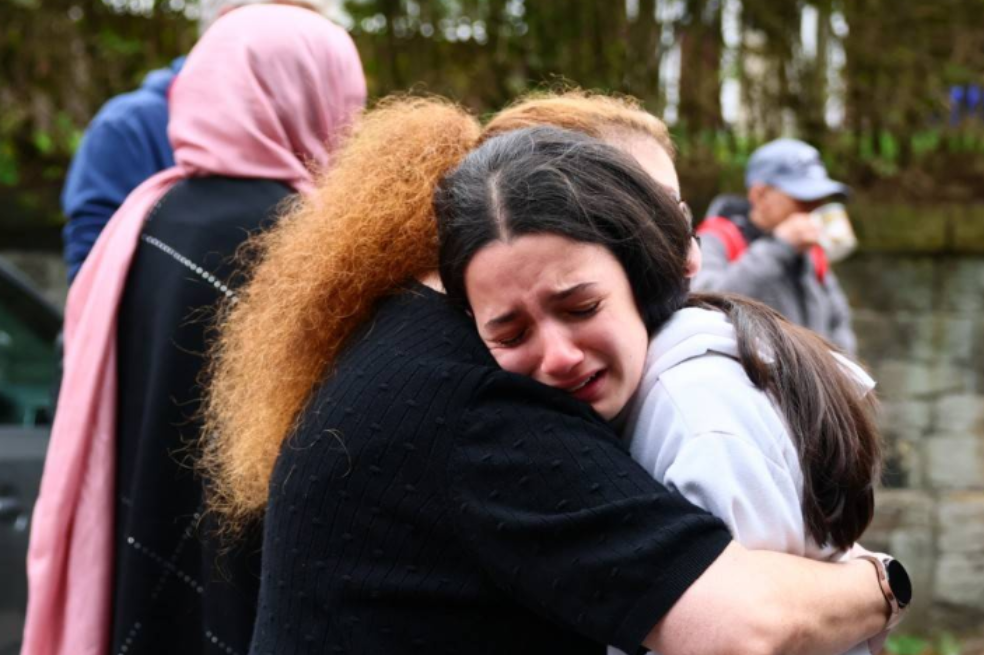 Members of the community comfort each other near Heaton Park Hebrew Congregation Synagogue in Crumpsall, north Manchester, on October 2, 2025, following a "major incident" at the synagogue.