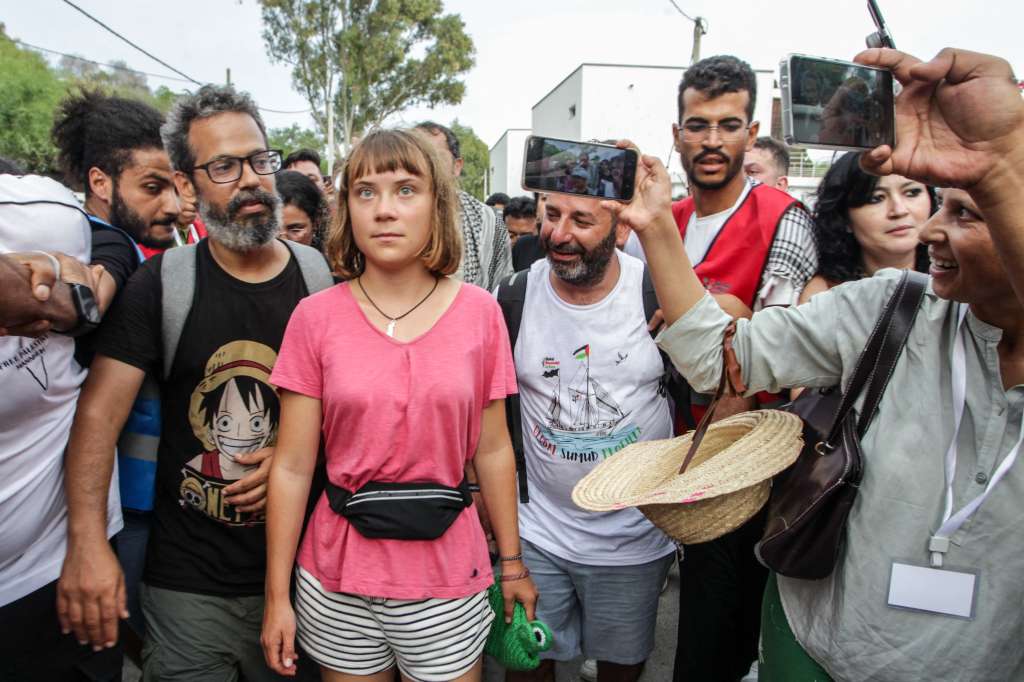 TOPSHOT - Swedish climate activist Greta Thunberg walks with a crowd of pro-Palestinian activists that arrived to greet the Global Sumud Flottila at the port of the village of Sidi Bou Said on September 7, 2025.