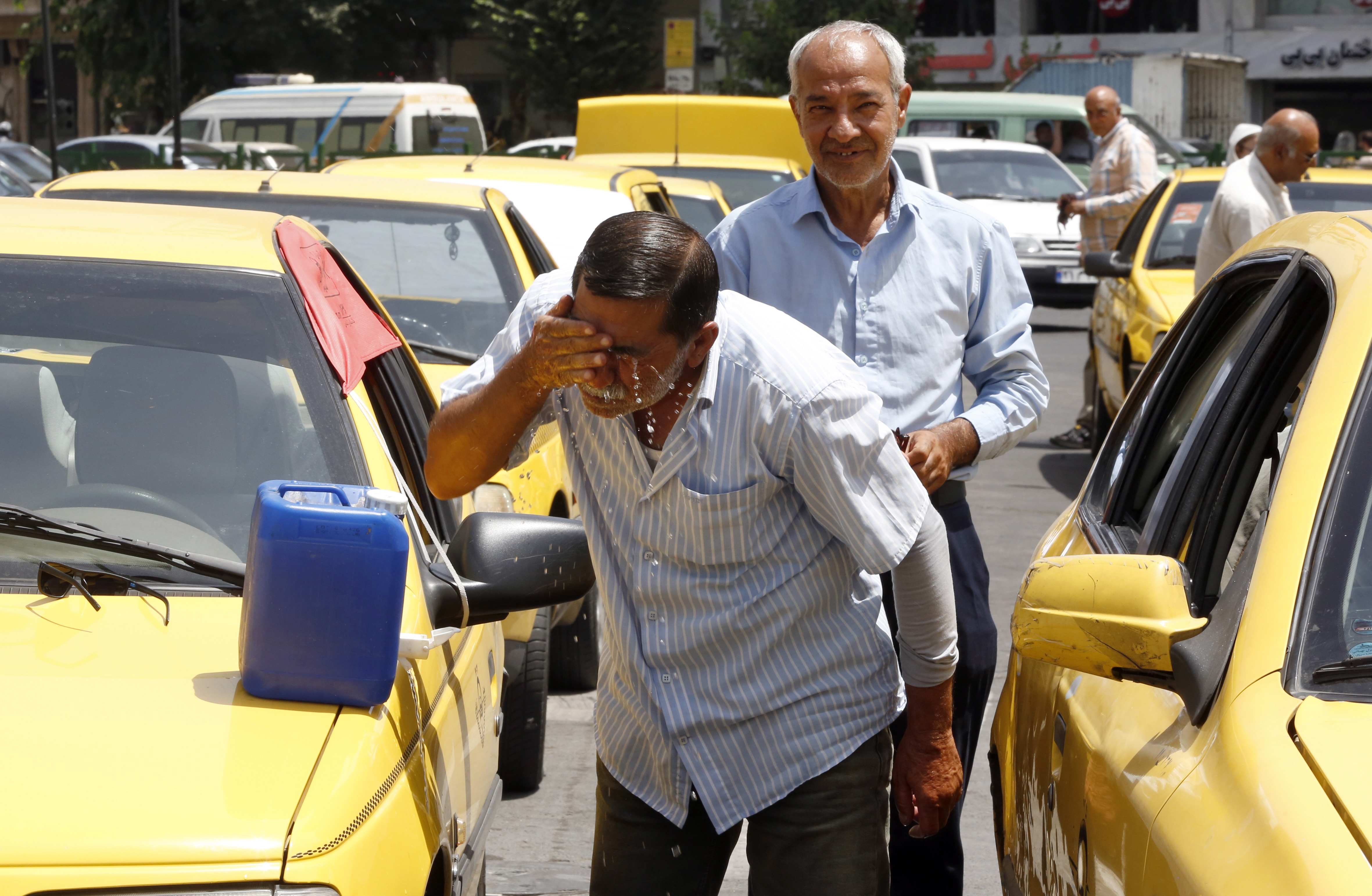 Tehran (Iran (islamic Republic Of)), 05/07/2023.- An Iranian Taxi driver splashes water into his face to cool off in a downtown street during a hot and sunny day in Tehran, Iran, 05 July 2023. Iran is facing a heat wave weather with temperatures above 35 degrees Celsius and forcasters'predictions of up to 40 degrees and more in the upcoming week. (Teherán) EFE/EPA/ABEDIN ATEHRKENAREH