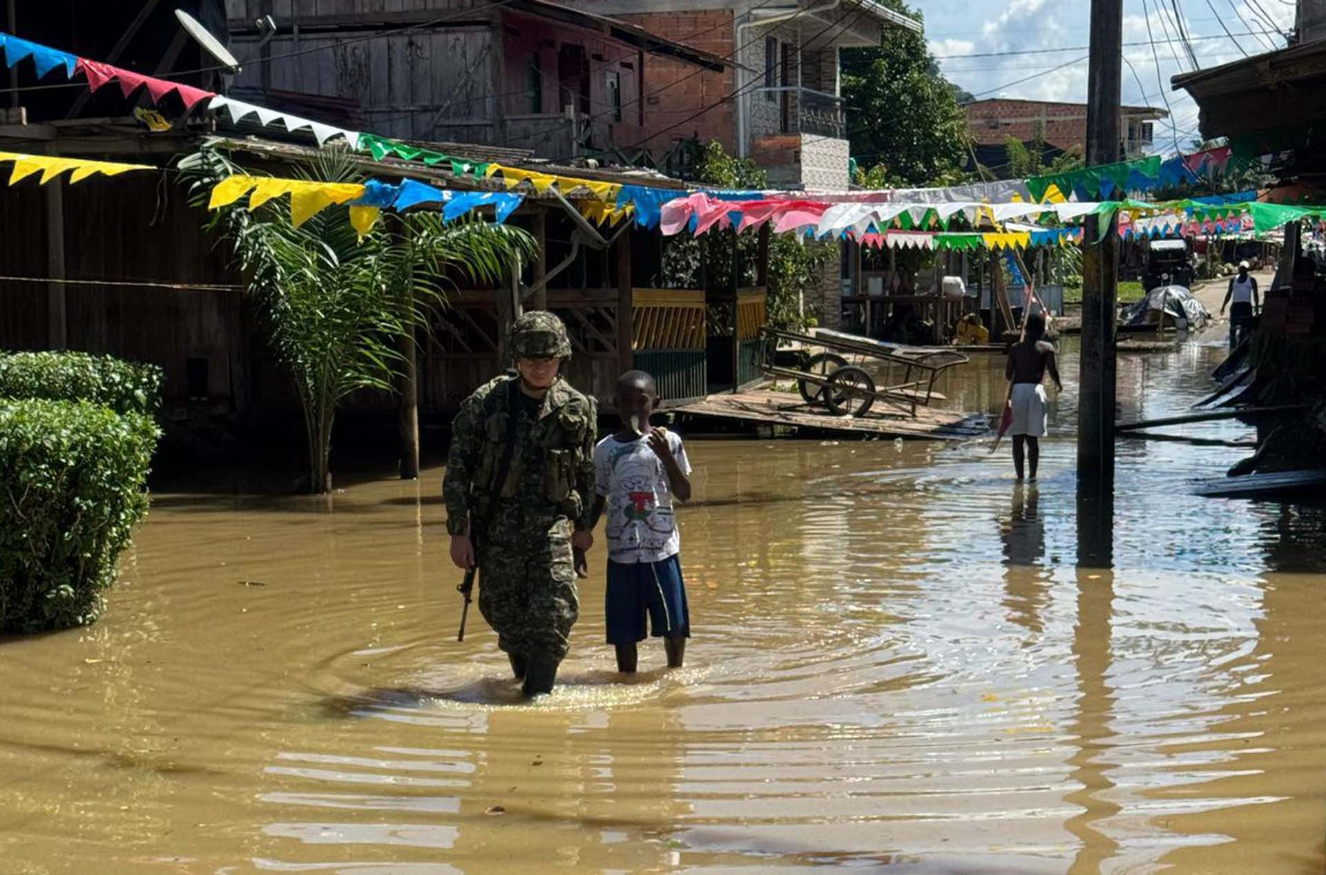 BOG700. ALTO BAUDÓ. (COLOMBIA), 11/11/2024.- Fotografía cedida por el Ejército de Colombia de militares que muestra a un solado acompañando a un joven por una calle inundada, este lunes en Alto Baudó (Colombia). El Ejército de Colombia entregó este lunes más de 300 kits de ayuda humanitaria en el departamento colombiano del Chocó, en la costa Pacífica, donde más de 100.000 personas resultaron damnificadas por las fuertes lluvias e inundaciones que durante el fin de semana afectaron a 25 municipios de esta región. EFE/Ejército de Colombia /SOLO USO EDITORIAL/SOLO DISPONIBLE PARA ILUSTRAR LA NOTICIA QUE ACOMPAÑA (CRÉDITO OBLIGATORIO) MÁXIMA CALIDAD DISPONIBLE