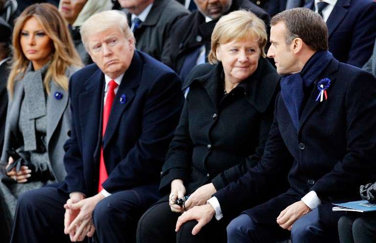 El presidente de Estados Unidos, Donald Trump, mira de reojo a Emmanuel Macron y Angela Merkel durante la conmemoración de los 100 años del armisticio. / AFP