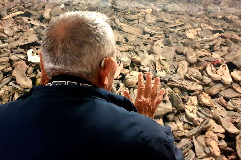 AUSCHWITZ, 22/09/2022.-Arie Pinsker, superviviente de Auschwitz, observa la galería acristalada del museo de Auschwitz donde hay una montaña de zapatos que pertenecieron a las víctimas del campoque van a ser conservados en el museo.-EFE/Miguel Ángel Gayo Macías