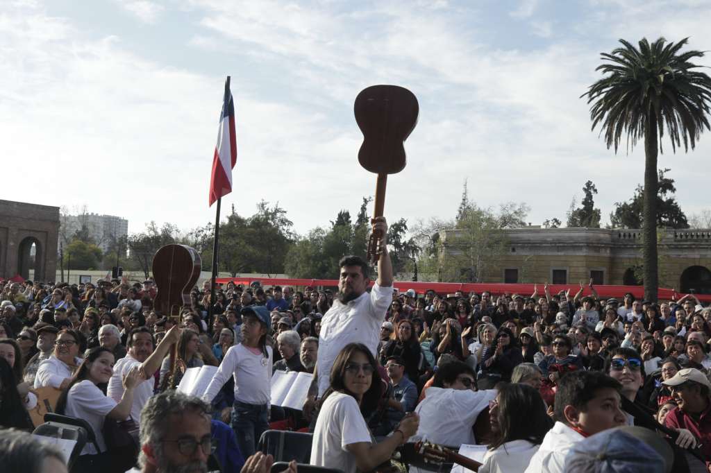 AME1012. SANTIAGO (CHILE), 19/09/2023.- Músicos y asistentes alzan guitarras durante un acto en honor a Víctor Jara, hoy en Santiago (Chile). Durante el acto, conocido como las mil guitarras", se rindió homenaje al cantautor que fue torturado y asesinado por la dictadura de Augusto Pinochet. EFE/ Javier Martín Rodríguez