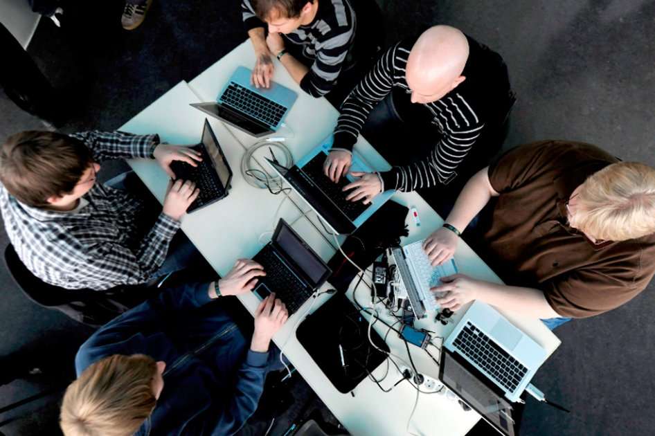 Varias personas trabajan en sus computadores.