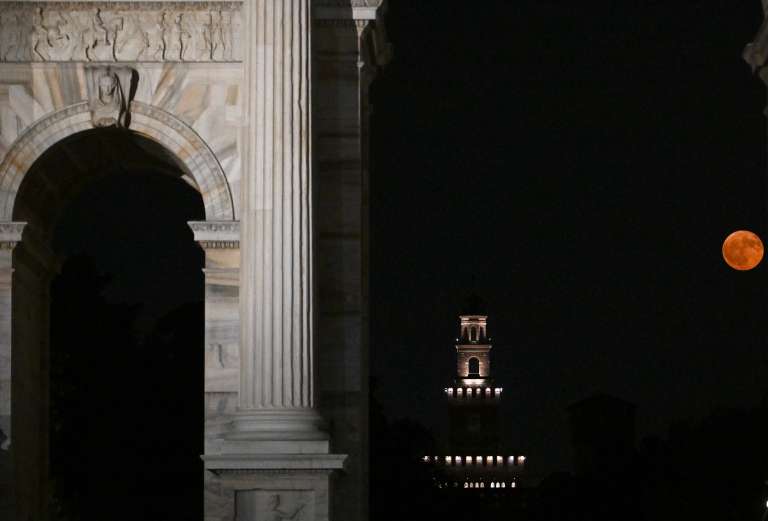 La luna llena, conocida como la «Luna de fresa», se eleva detrás del Arco della Pace («Arco de la Paz») y la torre del Castillo Sforza en Milán, el 11 de junio de 2025.