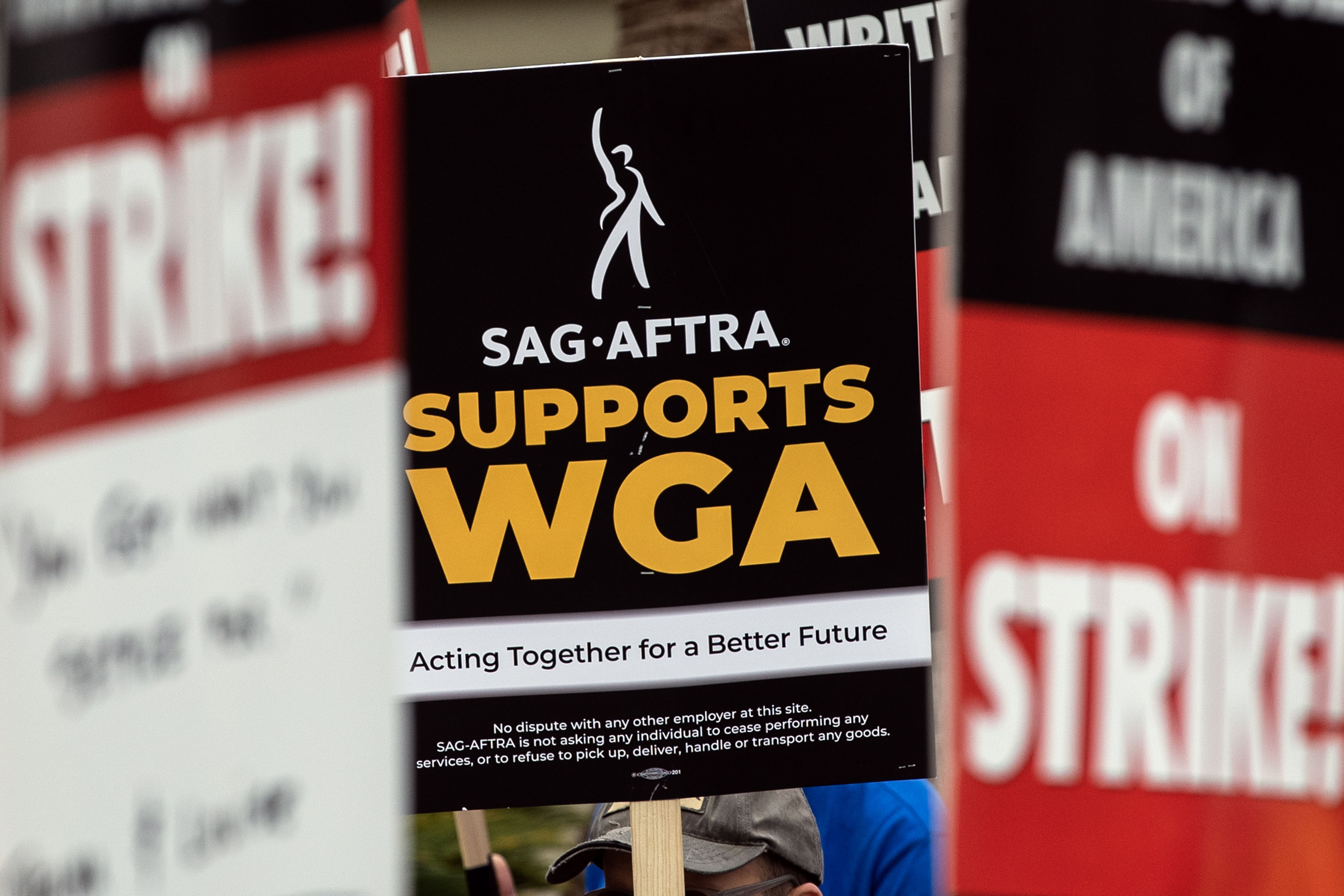 USA8437. LOS ÁNGELES (CA, EEUU), 08/07/2023.- Fotografía de archivo fechada el 6 de junio de 2023 que muestra a un manifestante mientras sostiene un cartel que dice "el Sindicato de Actores de Cine-Federación Estadounidense de Artistas de Radio y Televisión (SAG-Aftra) apoya al Sindicato de Guionistas de Estados Unidos (WGA)", frente a los estudios Paramount en Los Ángeles, California (EE.UU). Hollywood se sumerge en la incertidumbre ante la amenaza de huelga del sindicato de actores (SAG-AFTRA) y la prolongación del parón de los guionistas: mientras los segundos se mantienen firmes, los intérpretes tensan la cuerda con la búsqueda de un acuerdo con los estudios para crear un nuevo convenio colectivo. EFE/Etienne Laurent /ARCHIVO