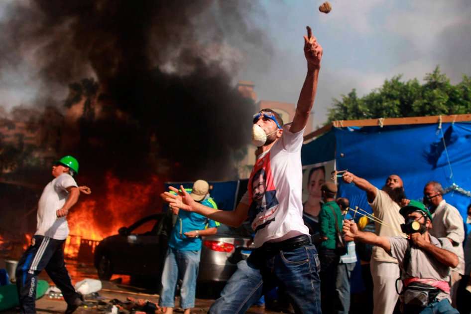 Manifestantes lanzan piedra contra las fuerzas de seguridad en El Cairo. Foto: EFE
