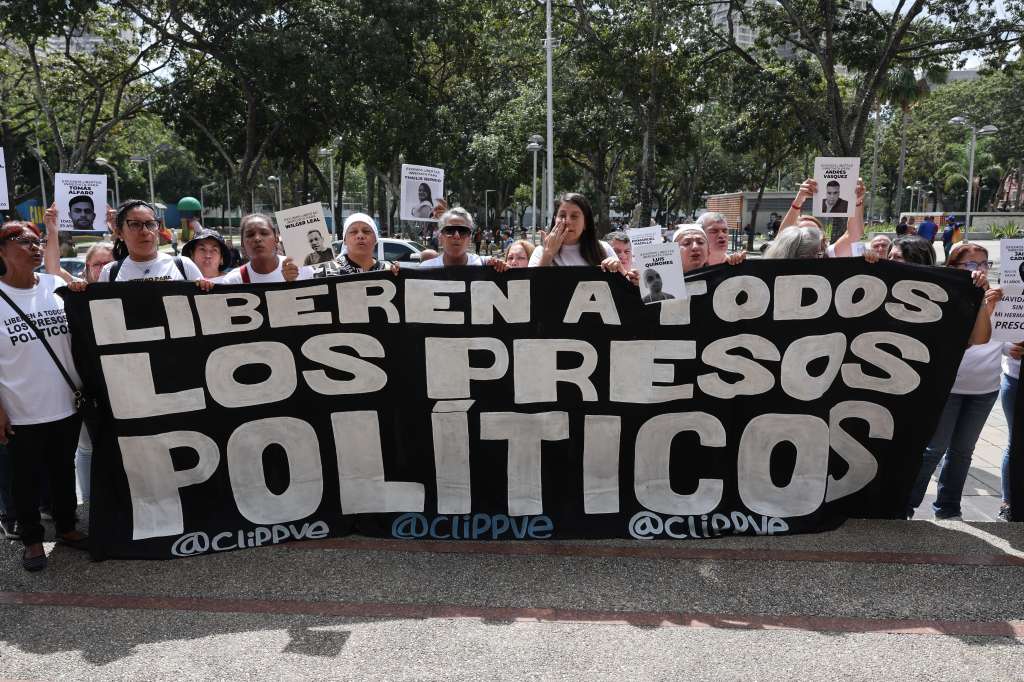 AME9789. CARACAS (VENEZUELA), 21/11/2024.- Familiares de detenidos sostienen una pancarta este jueves, afuera de la sede del Ministerio Público en Caracas (Venezuela). Decenas de personas en Venezuela protestaron este jueves frente a la Fiscalía General para exigir que se produzcan nuevas liberaciones de quienes fueron detenidos tras las presidenciales del 28 de julio, luego de que en los últimos días la Justicia dictase 225 medidas cautelares a favor de algunos de ellos. EFE/ Miguel Gutierrez