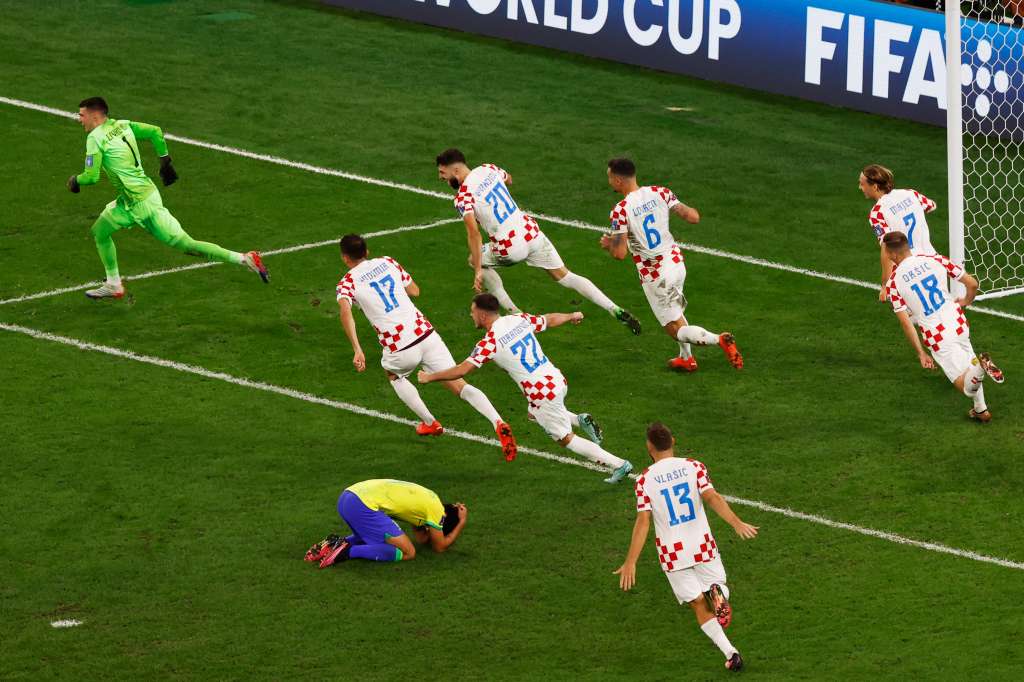 Doha (Qatar), 09/12/2022.- Players of Croatia run in celebration as Marquinhos of Brazil reacts on the ground after his penalty shot hit the post, which led to the elimination of Brazil during the FIFA World Cup 2022 quarter final soccer match between Croatia and Brazil at Education City Stadium in Doha, Qatar, 09 December 2022. (Mundial de Fútbol, Brasil, Croacia, Catar) EFE/EPA/Rolex dela Pena