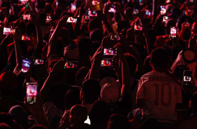 Doha (Qatar), 20/11/2022.- Fans raise their mobile phones to record the opening ceremony viewed on the screen at the FIFA World Cup 2022 Fan Festival in Doha, Qatar 20 November 2022. The World Cup 2022 opens with the first match between Qatar and Equador. (Mundial de Fútbol, Catar) EFE/EPA/ROLEX DELA PENA