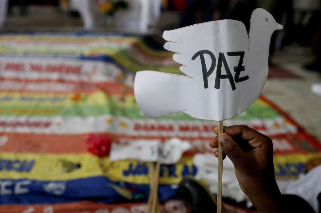 AME2640. BOJAYÁ (COLOMBIA), 02/05/2024.- Una persona sostiene un letrero en forma de paloma que dice 'Paz' durante la conmemoración de los 22 años de la masacre de Bojayá este jueves, en Bojayá (Colombia). Las comunidades afrodescendientes e indígenas de Bojayá, municipio del departamento colombiano del Chocó (oeste), protagonizaron este jueves un acto de conmemoración por los familiares y amigos fallecidos en la masacre que hace 22 años acabó con la vida de más de un centenar de personas. EFE/Luis Eduardo Noriega Arboleda