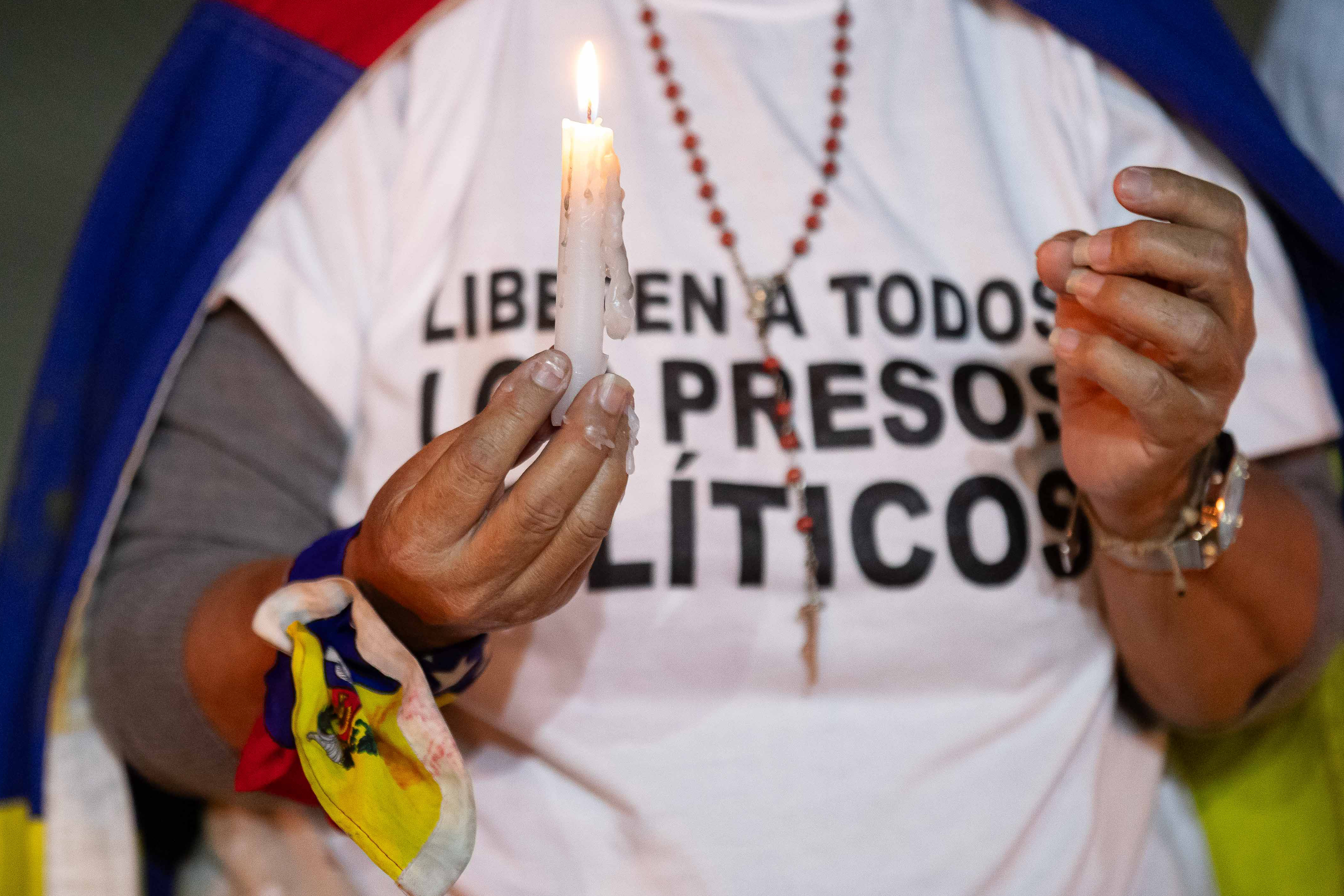 AME6105. CARACAS (VENEZUELA), 17/12/2024.- Una mujer sostiene una vela durante una vigilia por los "presos políticos" en la Universidad Central de Venezuela (UCV) este martes, en Caracas (Venezuela). Familias venezolanas se concentraron para iniciar una vigilia de oración por los tres "presos políticos" fallecidos bajo custodia del estado y, además, para pedir la libertad de aquellos que permanecen en la cárcel por estos motivos, la mayoría detenidos en contexto de protestas poselectorales. EFE/ Ronald Peña