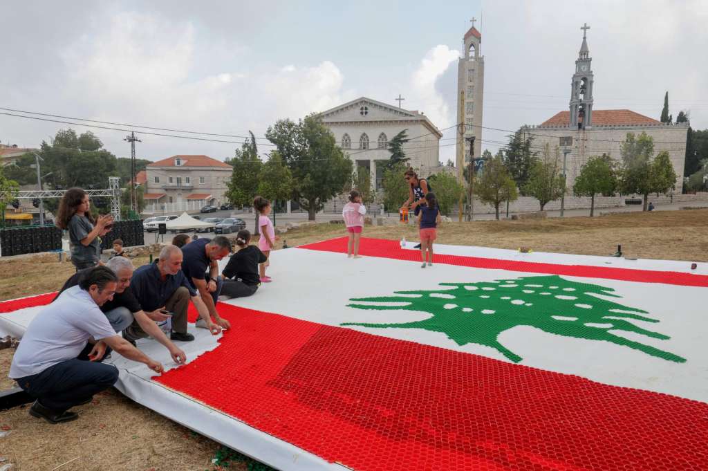 AAJALTOUN (Lebanon), 07/07/2026.- People work on a 70-square-meter Lebanese flag made of 10,452 bottle caps by Lebanese recycling artist Caroline Chaptini in her latest project on display in the village of Aajaltoun, northeast of Beirut, Lebanon, 07 July 2026. The number 10,452 represents the total area of Lebanon in square kilometers. (Líbano) EFE/EPA/WAEL HAMZEH EDITORIAL USE ONLY