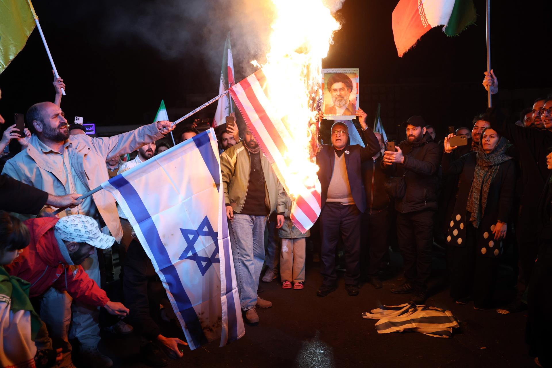 TEHRAN (IRAN(Islamic Republic Of)), 07/04/2026.- Iranians burn U.S. and Israeli flags during a demonstration following the announcement of a two-week ceasefire at Enghelab Square in Tehran, Iran, 08 April 2026. Iran and the USA agreed to the two-week truce to halt military operations and keep the Strait of Hormuz open for oil and gas shipments, with formal peace talks set to begin in Islamabad on 10 April. (Teherán) EFE/EPA/ABEDIN TAHERKENAREH