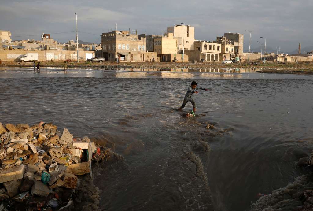 Sana'a (Yemen), 16/03/2023.- A Yemeni wades and attempts to traverse a torrent of rainwater flooding a stream littered with waste following heavy rainfall in Sana'a, Yemen, 16 March 2023. Torrential rains and associated floods have hit most parts of Yemen. (Inundaciones) EFE/EPA/YAHYA ARHAB
