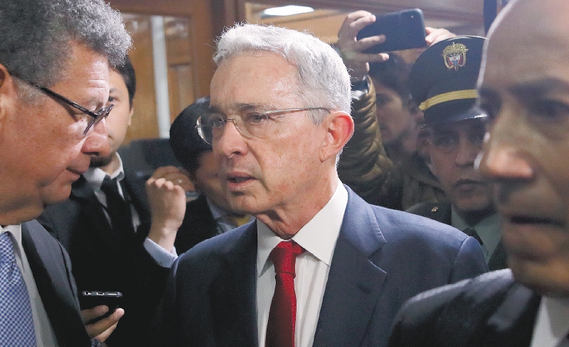 Former president Alvaro Uribe arrives to the Supreme Court for questioning in a case an involving witness tampering in Bogota, Colombia, Tuesday, Oct. 8, 2019. Uribe is under investigation over allegations he made false accusations and tried to influence members of a former paramilitary group in a case he had started by accusing leftist Senator Ivan Cepeda of plotting to falsely tie him to right-wing paramilitary groups. (AP Photo/Ivan Valencia)