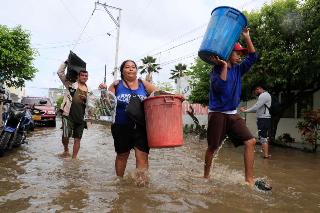AME2911. MONTERÍA (COLOMBIA), 07/02/2026.- Personas intentan rescatar sus pertenencias este sábado luego de una nueva creciente del río Sinú que afectó el barrio El Dorado en Montería (Colombia). El presidente colombiano Gustavo Petro anunció que decretará un nueva emergencia social, económica y ambiental para hacerle frente a las inundaciones que afectan gran parte de Colombia. EFE/ Carlos Ortega
