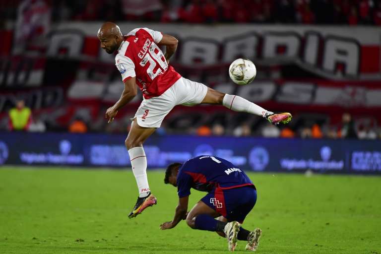 Edwar López (Santa Fe) trata de controlar una pelota, mientras que Léider Berrío (Medellín) pierde estabilidad.