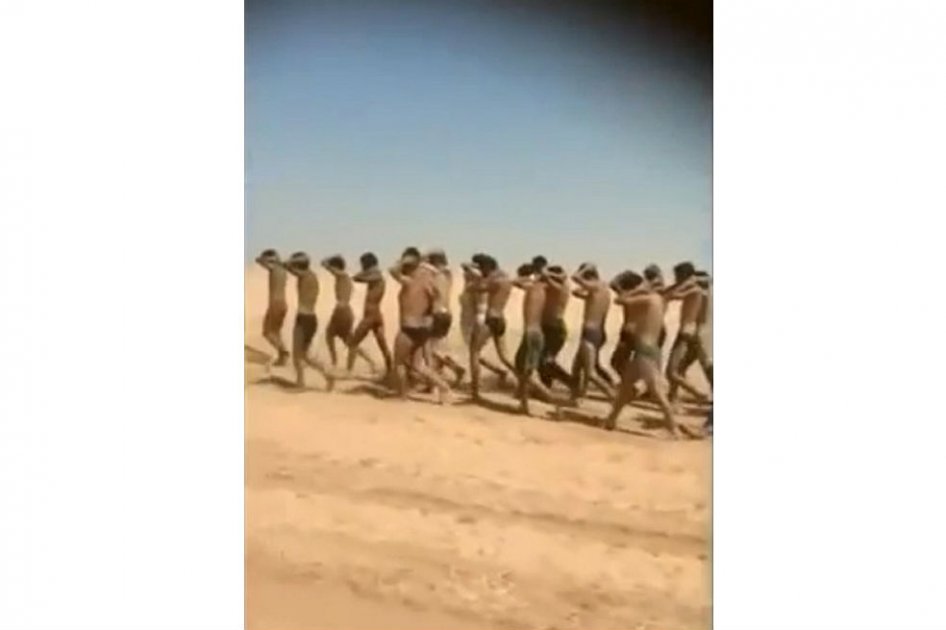 Imagen tomada de un video que muestra a varios hombres en ropa interior que caminan en el desierto antes de ser presuntamente ejecutados.