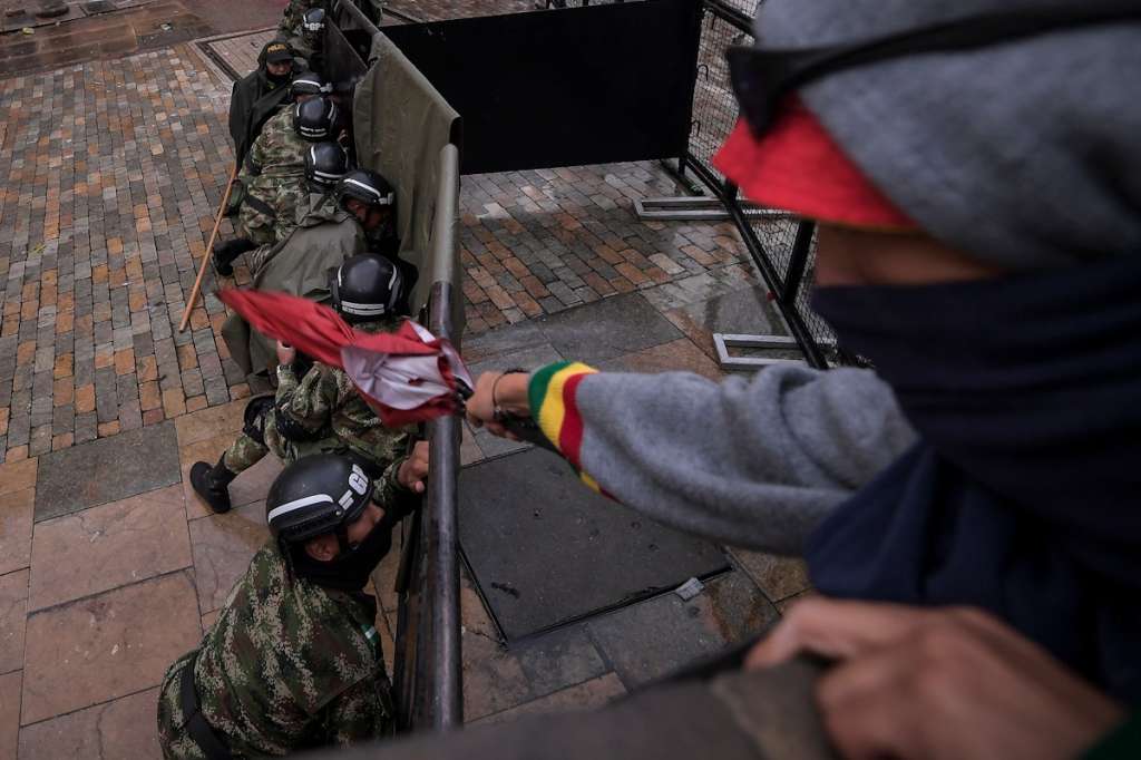Ante el ataque de los encapuchados, los uniformados se protegieron con las vallas de seguridad que se habían dispuesto en la Plaza de Bolívar. / Mauricio Alvarado - El Espectador